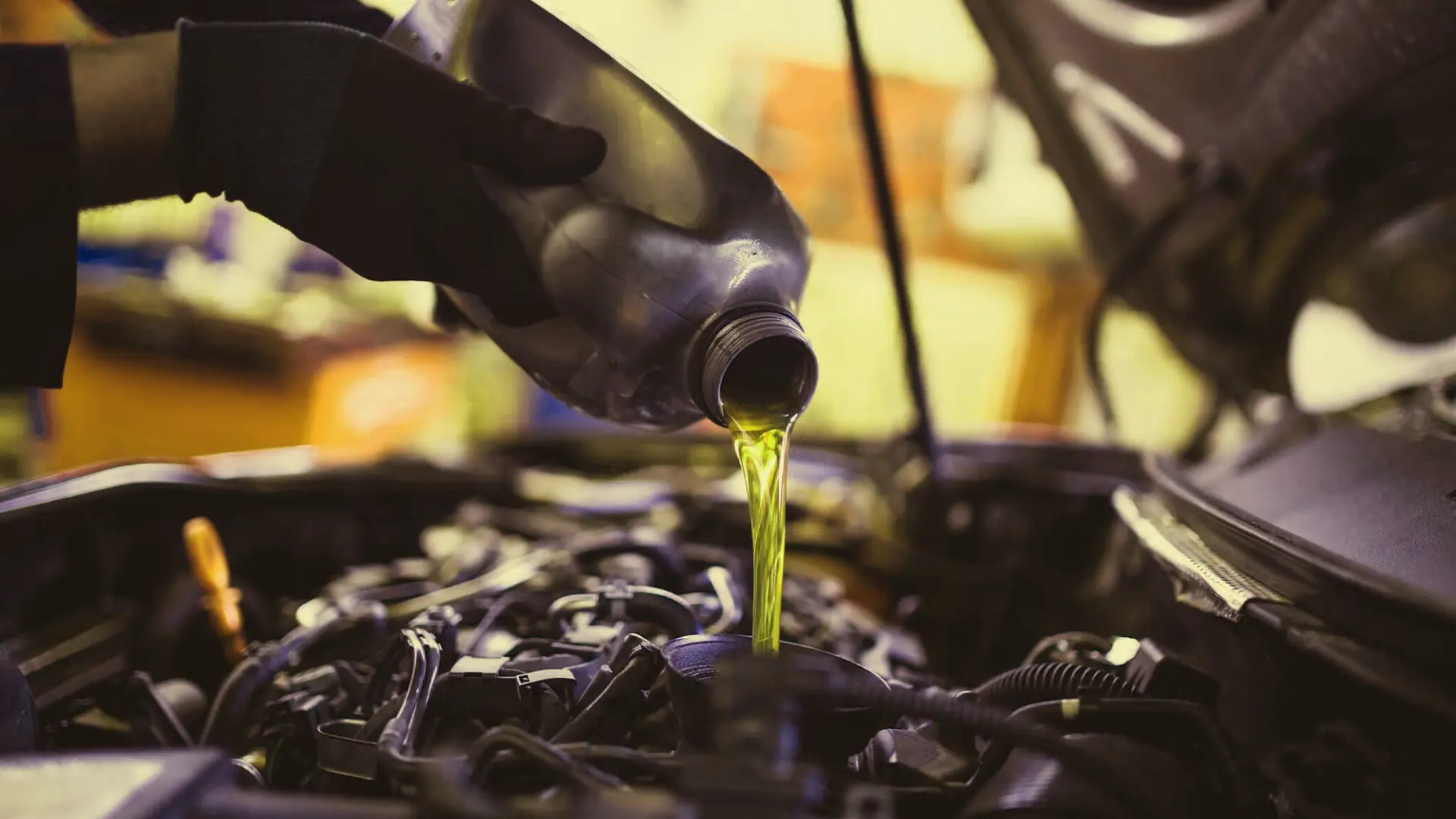 Mechanic pouring high-quality Fubex synthetic engine oil into a car engine to ensure maximum lubrication and vehicle longevity.